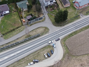 Kontrola drogowa kierującego przez policję na poboczu drogi widziana z góry.