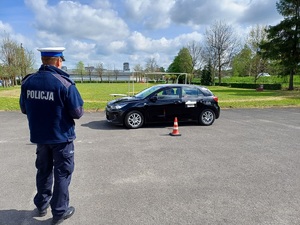 Policjant obserwuje jazdę samochodem z zamontowanym talerzem Stewarta jednego z uczestników turnieju