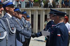 Komendant wręcza akt mianowania policjantowi.