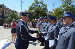 Komendant wręcza róże policjantce.