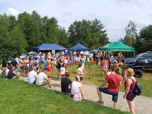 Uczestnicy pikniku przy namiotach profilaktyczno-promocyjnych służb mundurowych.