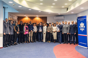 Pracownicy cywilni stoją razem z komendantami, obok baner gorlickiej jednostki.