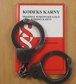 Na kodeksie karnym leżą policyjne kajdanki.