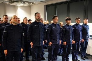 Policjanci stoją w szeregu na sali.