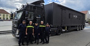 Przed samochodem ciężarowym stoją policjanci.