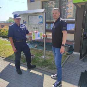 Policjant i osoba przed wejściem do spółdzielni mieszkaniowej.