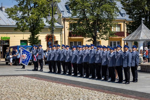 Pododdział policji stoi na rynku w Bieczu. W tle zgromadzeni mieszkańcy Biecza.