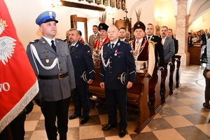 W kościele policjanci i zaproszeni goście stoją w ławkach.