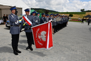 Poczet sztandarowy i pododdział policjantów.