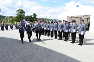 Poczet sztandarowy przed pododdziałem policjantów odprowadza sztandar.