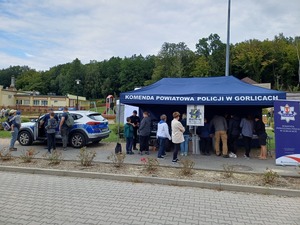 Obok policyjnego namiotu stoi policyjny radiowóz.