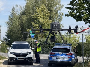 Policjant-na-drodze-stoi-obok-kontrolowanego-samochodu_-obok-stoi-policyjny-radiowóz.