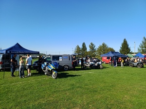 Dwa stoiska policyjne, a obok nich radiowozy, motocykle i quad.