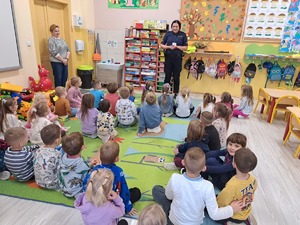 Policjantka rozmawia z dziećmi sali.