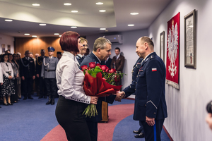 Komendant zdający stanowisko otrzymuje kwiaty i gratulacje.