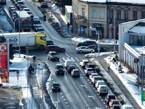 Skrzyżowanie dróg z jadącymi samochodami widziane z góry.