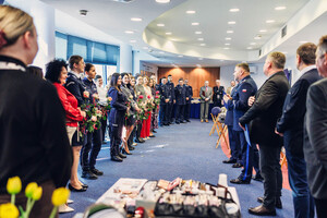 Pani stoją z różami  na przeciw składających życzenia.