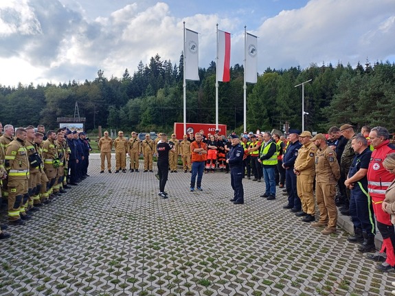 Wszystkie służby stoją na placu i słuchają podsumowania ćwiczeń.