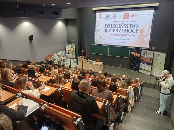 Na auli siedzą osoby i słuchają wystąpienia starosty.