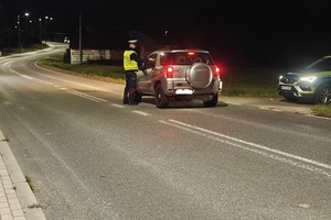 Policjant na drodze kontroluje samochód.