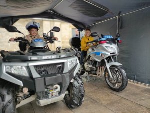 Dwóch chłopców siedzi na kładzie i motocyklu służbowym