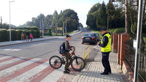 1.	Przez przejście dla pieszych przechodzi młody rowerzysta prowadząc rower. Policjant stojący za przejściem wręcza mu odblask.