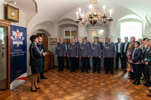 Komendant Powiatowy Policji w Gorlicach wraz z swoim zastępcą składa życzenia pracownikom Korpusu Służby Cywilnej. Obok stoi kadra kierownicza jednostki.