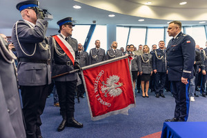 Komendant Wojewódzki Policji w Krakowie wita się ze sztandarem jednostki.