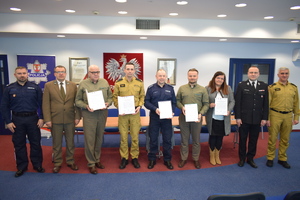 Przedstawiciele Policji Państwowej Straży Pożarnej, Nadleśnictw i Agencji Restrukturyzacji i Modernizacji Rolnictwa stoją i trzymają podpisany apel do mieszkańców dotyczące niewypalania traw