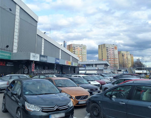 Galeria handlowa, a obok na parkingu stojące samochody.