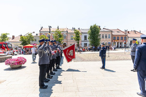 Zastępca Komendanta Wojewódzkiego Policji w Krakowie oddaje honor sztandarowi Komendy Powiatowej Policji w Gorlicach, Pododział policji stoi na baczność na rynku miasta.