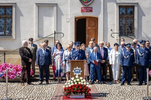 Zaproszeni goście stoją przed bieckim ratuszem w trakcie wystąpienia Komendanta Powiatowego Policji w Gorlicach