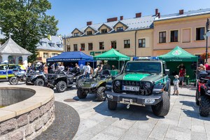 Na płycie rynku stoją pojazdy służbowe policji, straży granicznej i straży pożarnej. W tle namioty promocyjne służb mundurowych.