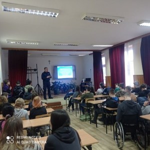 Uczniowie słuchają prelekcji policjanta.